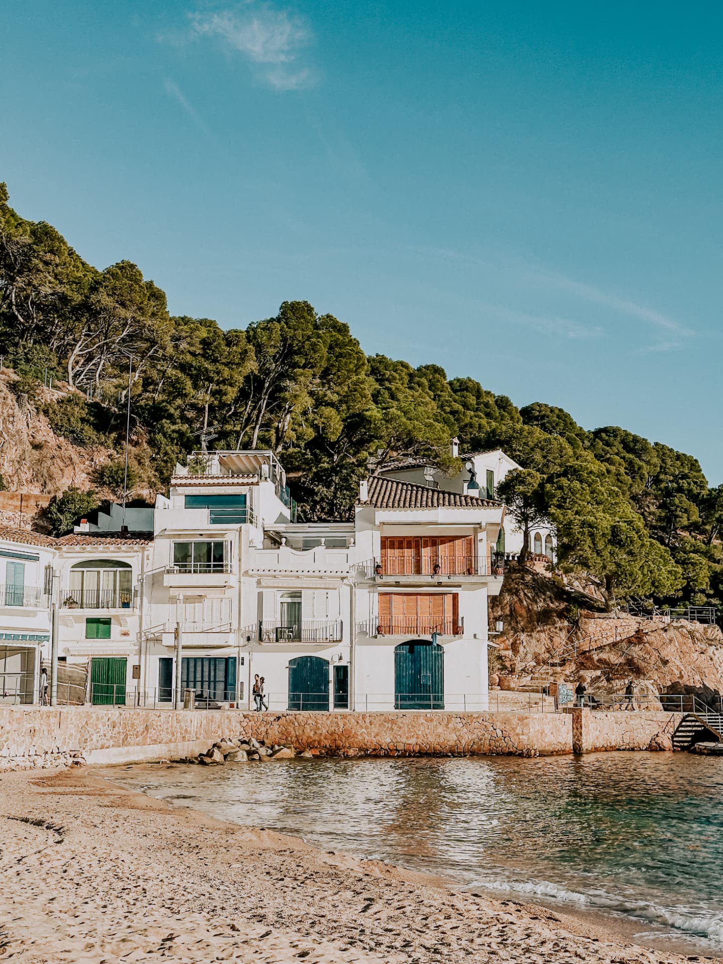 White waterfront houses beside a sheltered Costa Brava beach